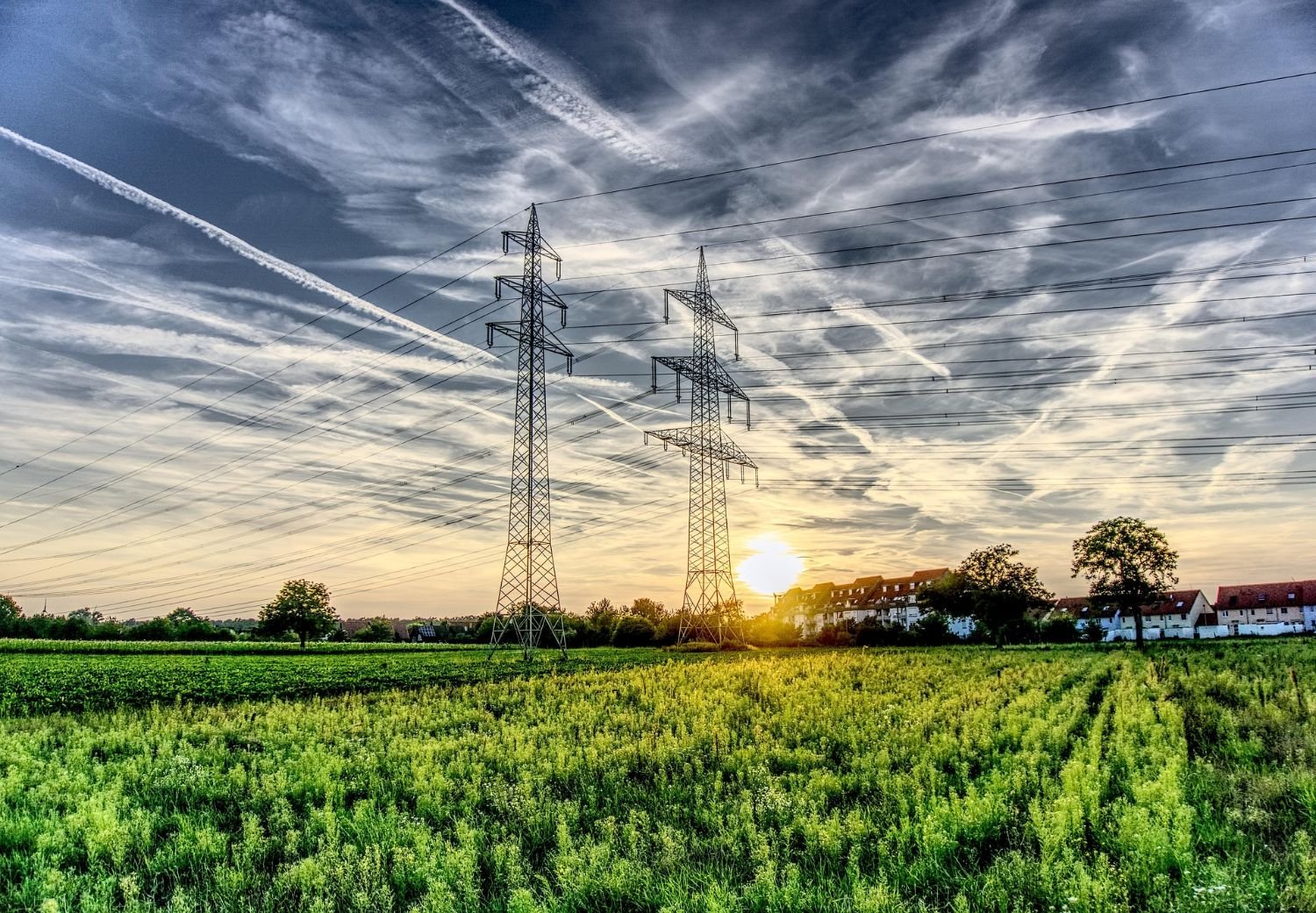 Torres y líneas de alta tensión al atardecer, mercado eléctrico